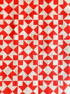 a red and white quilt with squares on it