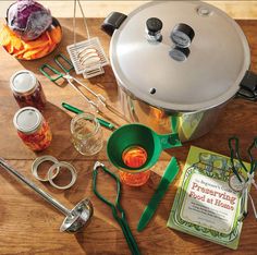 there are many cooking utensils on the table and one has a large pot