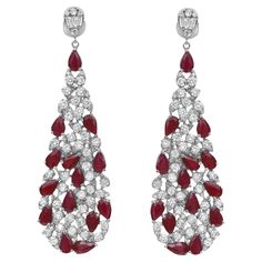 Shimmering ruby and diamonds sway along these stunning 14K white gold women's drop earrings. These earrings feature prong set pear cut rubies and round brilliant cut diamonds encrusted in a pear shaped mounting hanging from a small pear shape stud encrusted with round and baguette cut diamonds. Total diamond weight: 3.37 carats. Diamond quality: color G-H and clarity VS-SI. Total ruby weight: 5.99 carats. Earring length: 2.2 inches. Width: 0.6 inch. Total weight: 15.15 grams. Secured with pushba Luxury Ruby Diamond Earrings For Anniversary, Gold Diamond Drop Earrings, Gold Sign, White Gold Chains, Long Drop Earrings, Baguette Cut Diamond, Diamond Drops, Diamond Drop Earrings, Modern Earrings