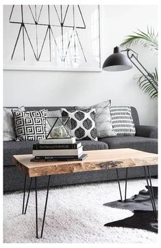 a living room filled with furniture and a wooden table on top of a white rug