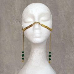 Unique Gold Face Chain Mask with Artificial Malachite Design Enhance your style with our Unique Gold Face Chain Mask. This accessory combines the elegance of gold with the deep green tones of malachite, creating a striking look that is perfect for festivals, photo shoots, parties, and more. The design is crafted to stand out, making it a perfect accessory for those looking to make a statement. Adjustable Fit for Comfort: The mask comes with an adjustable chain that allows for a customized fit, ensuring comfort and stability during wear. Versatile Use: Ideal for a range of occasions, including belly dance performances, festivals like Burning Man, Gothic-themed events, Halloween costumes, or simply adding a unique flair to your everyday look. This mask adds a touch of mystery and sophisticat Handmade Gold Body Chain For Party, Gold Body Jewelry With Adjustable Chain For Festivals, Adjustable Gold Headpiece For Masquerade, Gold Brass Body Jewelry For Festivals, Handmade Adjustable Gold Headpiece, Gold Goddess Headpiece For Party, Spiritual Gold Body Jewelry For Festivals, Elegant Adjustable Jewelry For Masquerade, Elegant Gold Jewelry For Masquerade