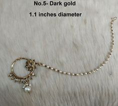 a close up of a necklace on a white surface with text stating no 5 dark gold 1 inches diamer