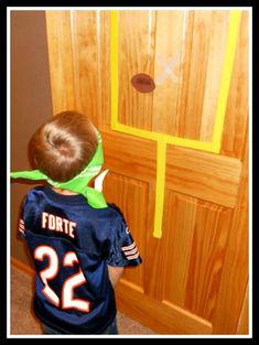 a young boy wearing a football jersey standing in front of a door with the number 22 on it