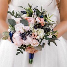 a woman holding a bouquet of flowers in her hands