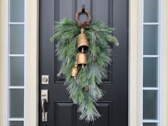 a christmas wreath with bells hanging on the front door