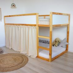 there is a bunk bed with curtains on the top and bottom, next to a rug