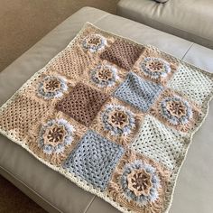 a crocheted granny blanket is sitting on a couch