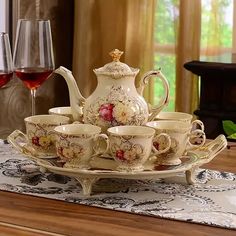 a tea set on a table with wine glasses