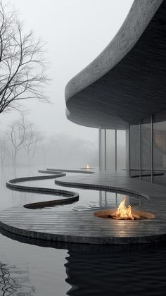 a fire pit in the middle of a pool surrounded by water and trees on a foggy day