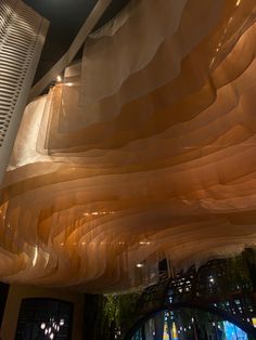 the ceiling is covered with sheer fabric and lights are shining down on the building's interior