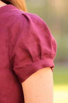 the back of a woman's maroon shirt with short sleeves