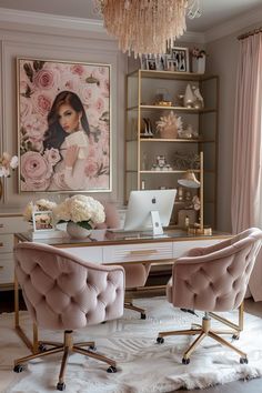 a desk with two chairs and a laptop on it in front of a pink painting