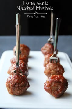 several meatballs are being cooked on skewers with toothpicks in them