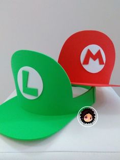 two hats are sitting on top of each other, one is green and the other is red