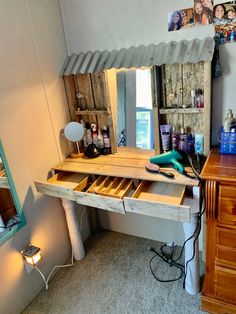 a wooden desk topped with lots of drawers under a mirror next to a wall mounted hair dryer