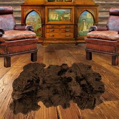 an animal rug is on the floor in front of two leather chairs and a dresser