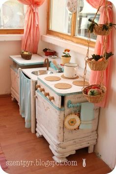 an old fashioned kitchen with pots and pans on the stove top, next to a window