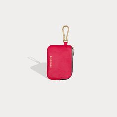 a pink case with a keychain hanging from it's side on a white background