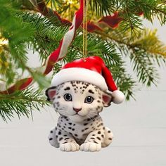 a snow leopard cub ornament hanging from a christmas tree