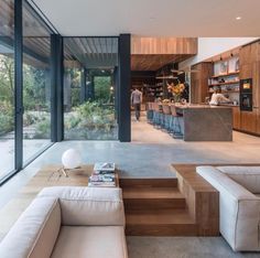 a living room filled with furniture next to a kitchen and an open concept dining area