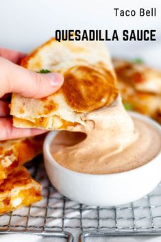 a hand dipping quesadilla sauce into a small white bowl on a wire rack