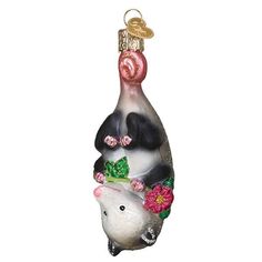 a glass ornament with an animal on it's back and flowers in the bottom