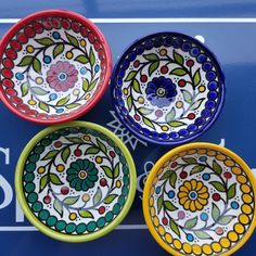 four colorful bowls sitting on top of a sign