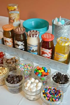 an assortment of desserts and confections are displayed in small glass containers on a table