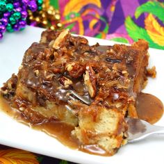 a piece of pecan bread pudding on a white plate with a spoon in it