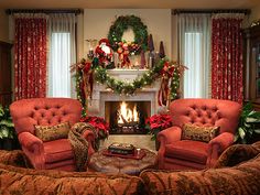 the living room is decorated for christmas with red furniture and decorations on the fireplace mantel