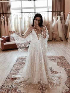 a woman is taking a selfie in front of her wedding gowns and dresses