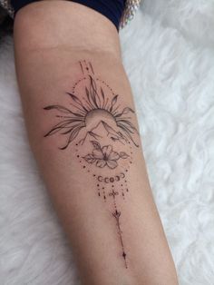 a woman's arm with a sun and moon tattoo on the left side of her leg