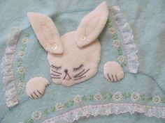 a close up of a stuffed animal on a blue blanket with white and pink flowers