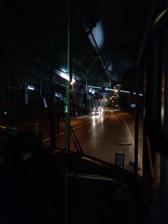 the interior of a bus at night with its lights on and cars driving down the road