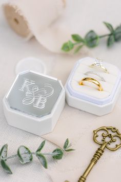 two wedding rings and a key on a table