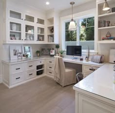 a home office with white cabinets and drawers