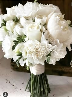 a bouquet of white flowers sitting on top of a table