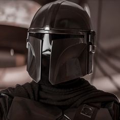 a star wars character wearing a black helmet