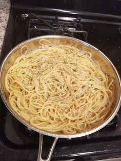 a pan filled with pasta sitting on top of an oven burner next to a stove