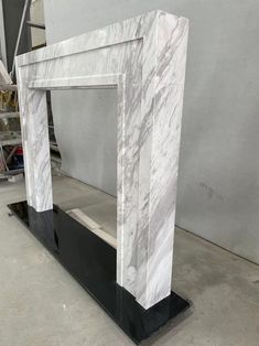 a white marble fireplace surround with black base