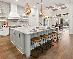 a large kitchen with an island and bar stools