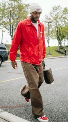 a man walking down the street with his handbag in his pocket and wearing an orange jacket