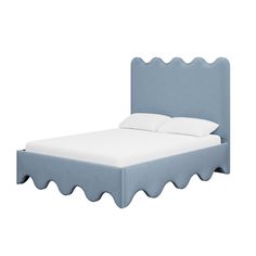 a blue bed with scalloped edges and white pillows on it's headboard