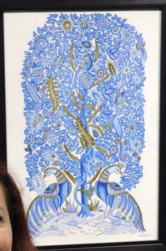 a woman standing in front of a blue and white tree with birds on it's branches