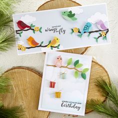 two cards with birds on them sitting on top of a tree branch next to pine branches