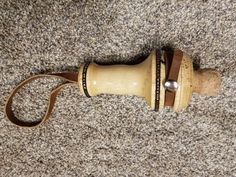 a close up of a wooden object on the ground with a cord attached to it