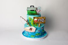 a three tiered cake decorated with an ocean theme and fishing related items on it