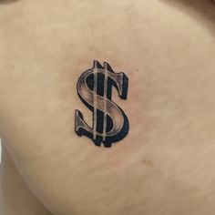 a small tattoo on the back of a woman's stomach depicting a dollar sign