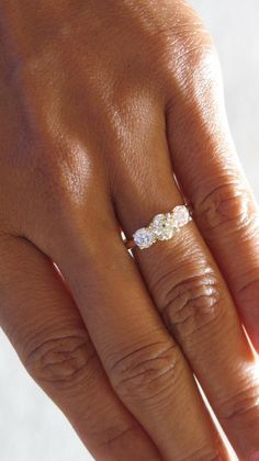 a woman's hand with a diamond ring on it