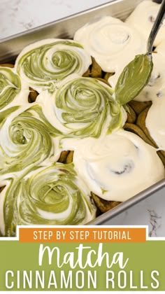 a pan filled with cinnamon rolls covered in cream cheese frosting and green icing